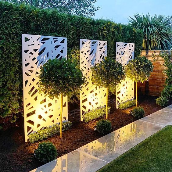 Decorative garden screens with plants and lighting in a backyard setting
