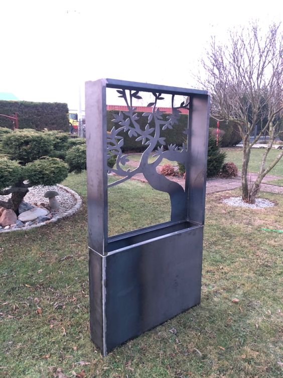 Decorative metal planter with cut-out design in a garden setting