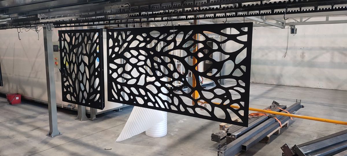 Decorative metal panels with intricate cut-out patterns on a stand.