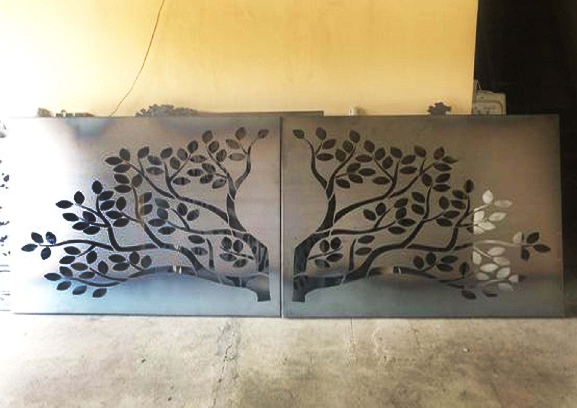 Decorative metal screen with tree design on a plain background