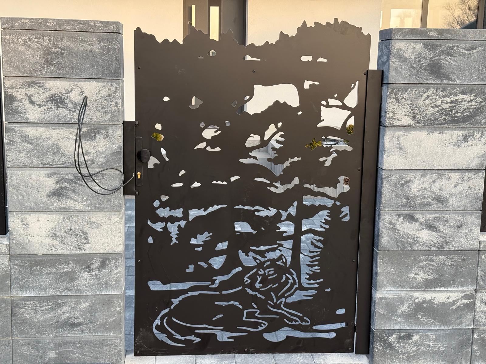 Decorative metal gate with a tiger design on a stone wall. wolf